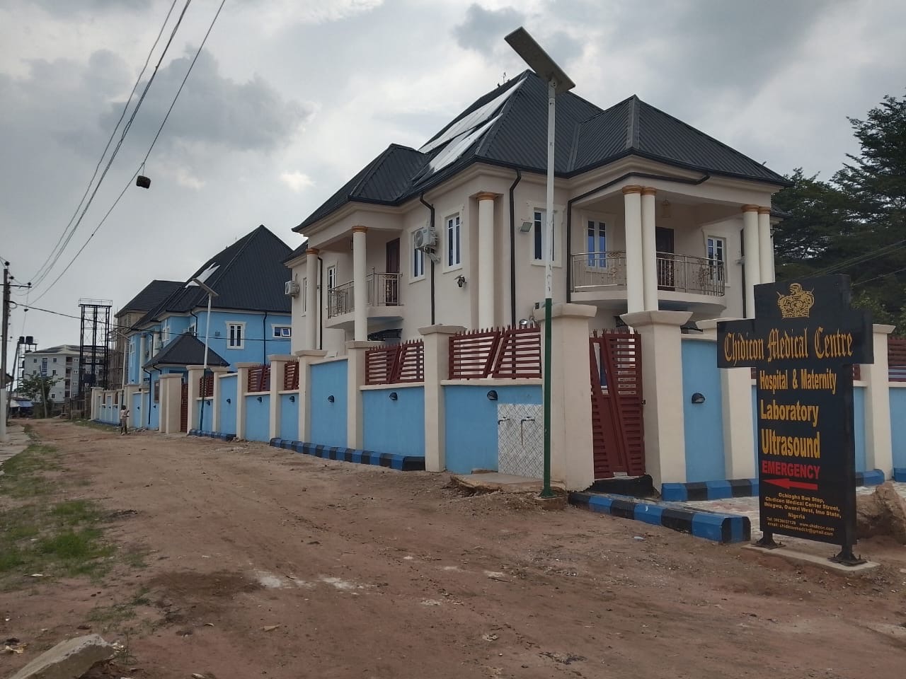 Exterior of Chidicon Medical Center in Ihiagwa, Owerri West, with blue perimeter wall and medical services sign